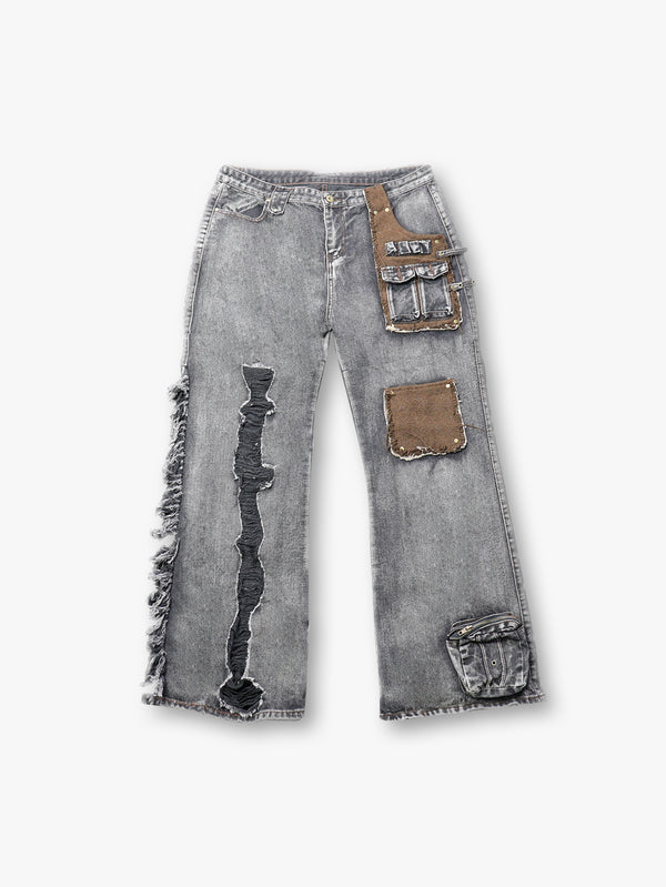 Pantalones cargo de mezclilla gris de estilo urbano con bolsillos de tela mixta y detalles de flecos asimétricos