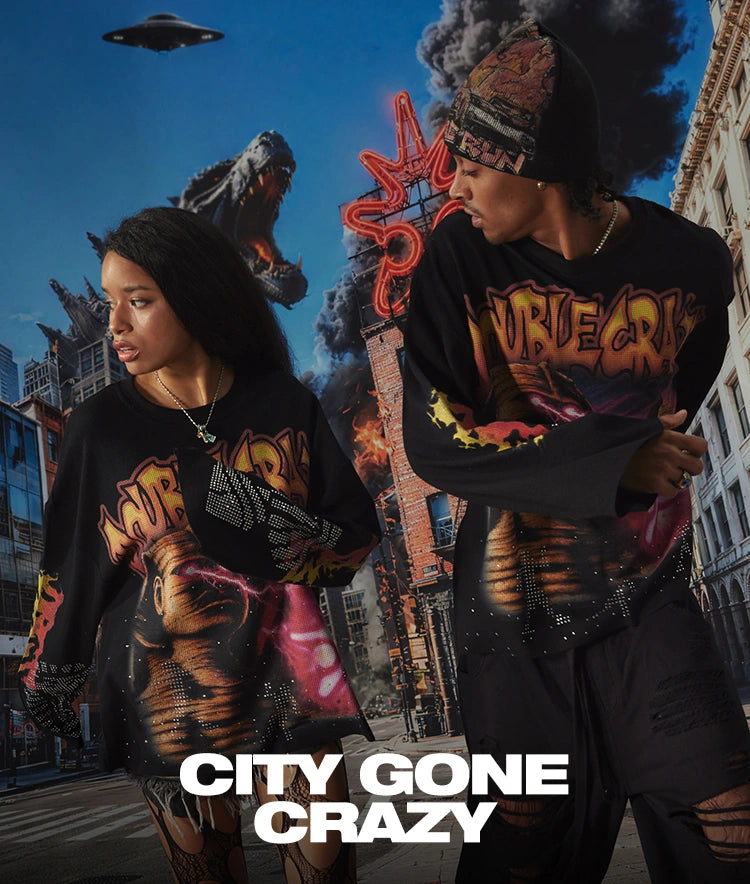 Two models wearing DoubleCrazy monster graphic long sleeves in a city-destruction scene for the City Gone Crazy collection.