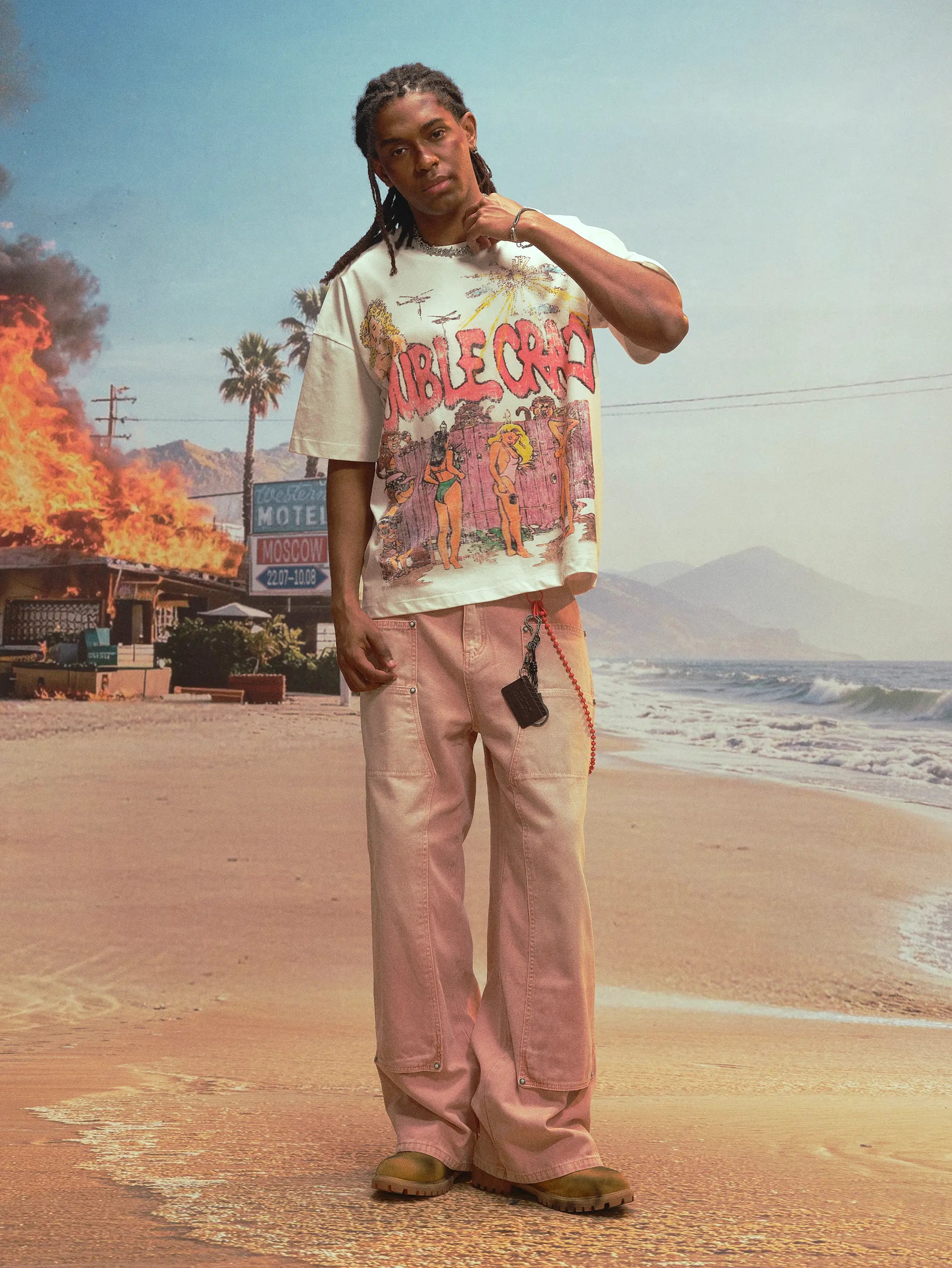 White vintage graphic tee styled with loose pants and beach streetwear mood